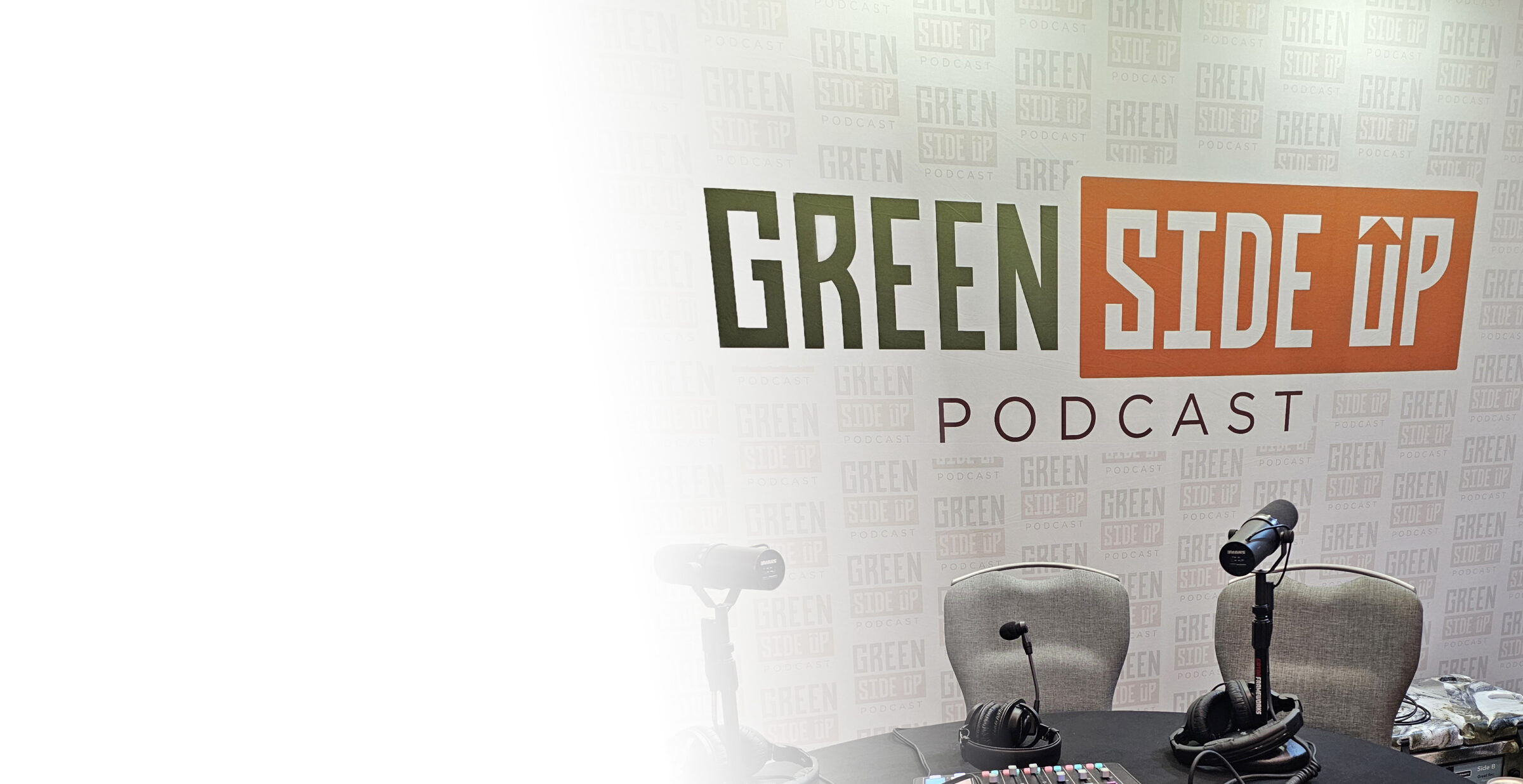 Podcast setup with microphones and chairs in front of a "Green Side Up Podcast" banner. No people are present.